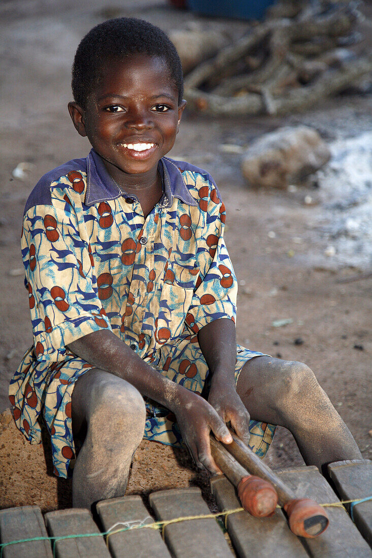 Lobi child playing balafon (typical Lobi instrument), Gaoua area. Lobi Country, Burkina Faso