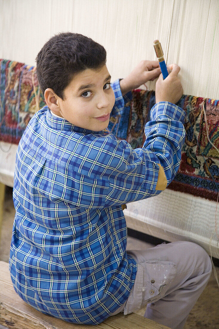 Young boy making carpet in training workshop near Saqqara. Egypt