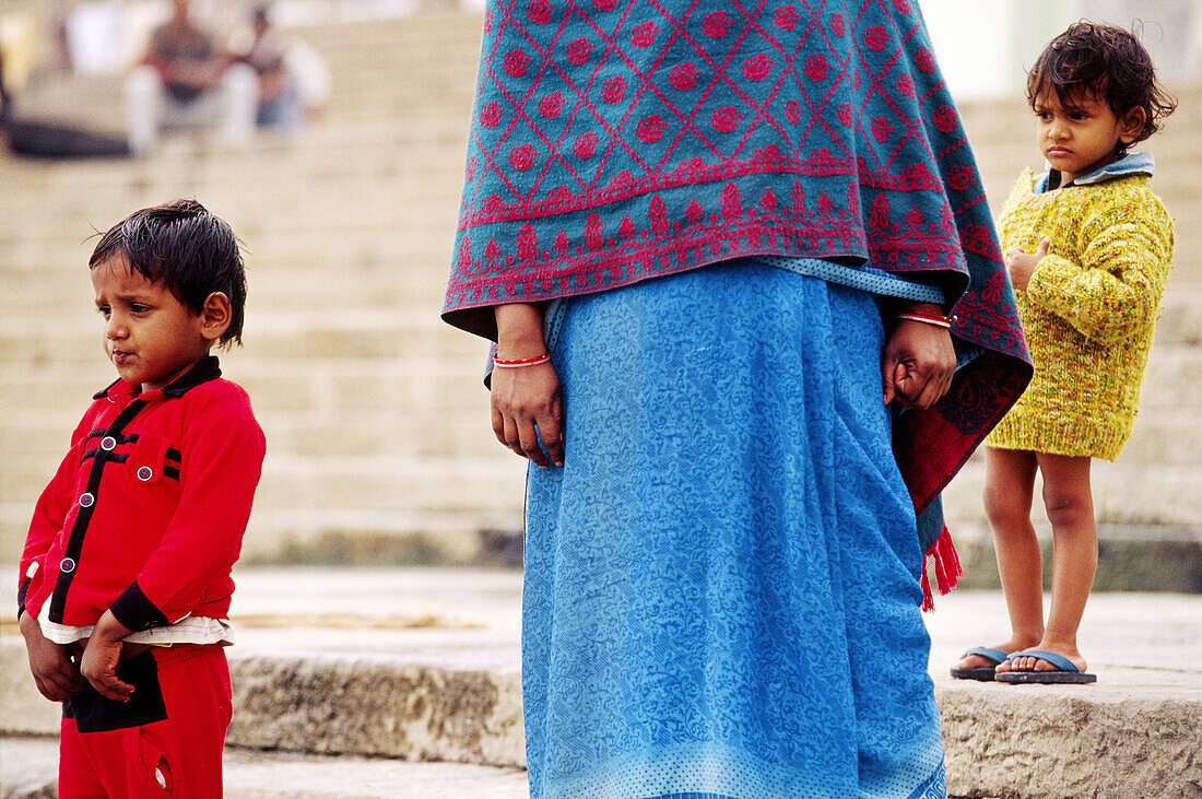 Children and mother in bright colourer clothes on the ghat steps Varanasi, India