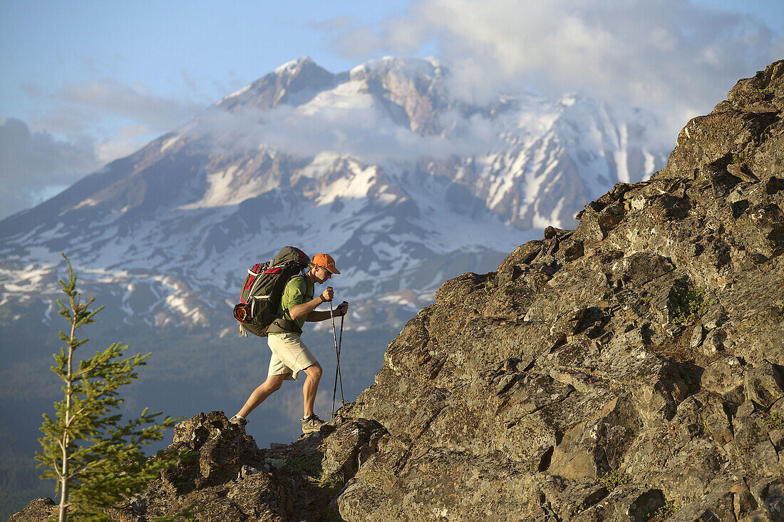 Man climbing a ridge while backpacking alone near Mount Adams Wilderness. Washington. USA