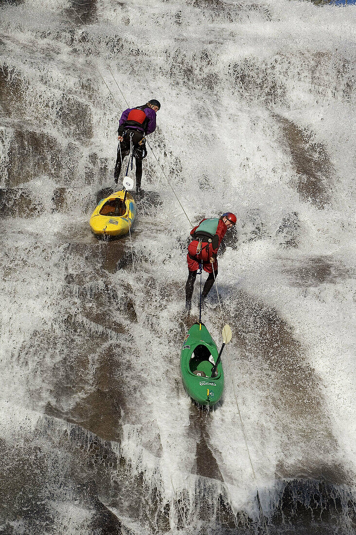 Two men rappelling down a waterfall near Lake Tahoe, California. USA