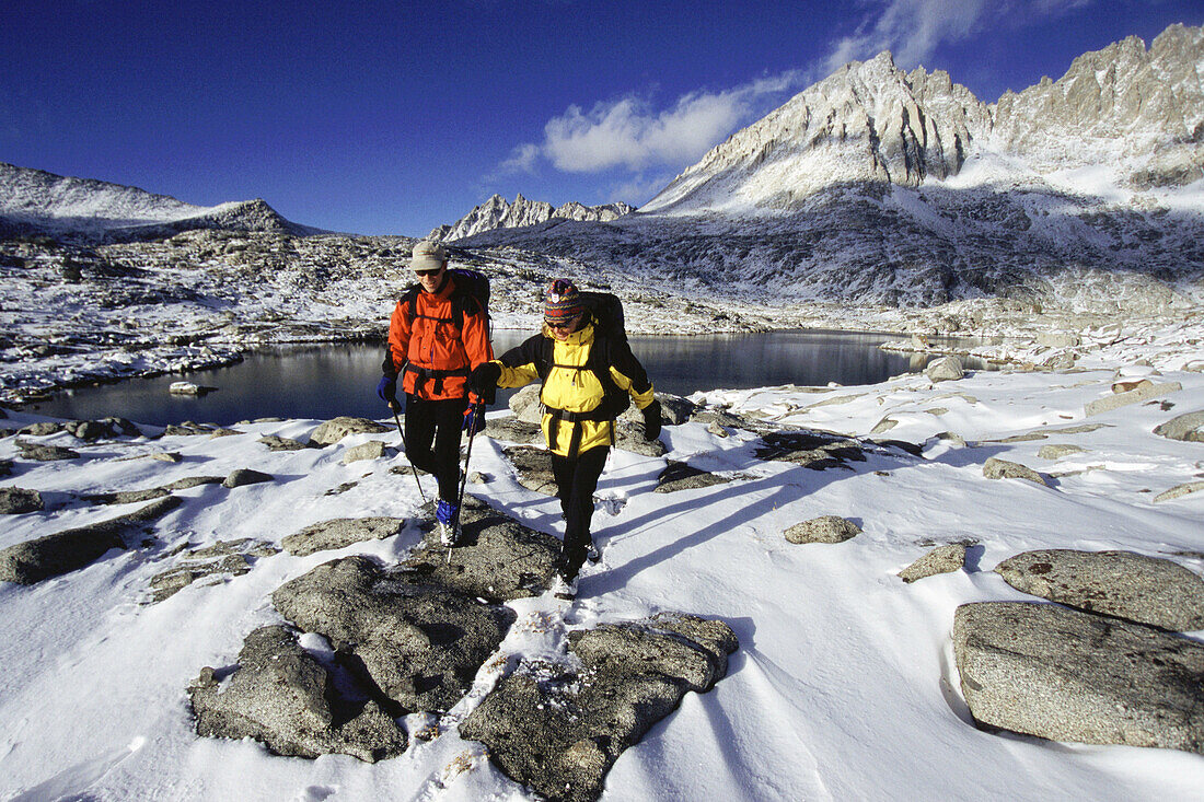 A couple hiking after a snowstorm in Dusy Basin, CA