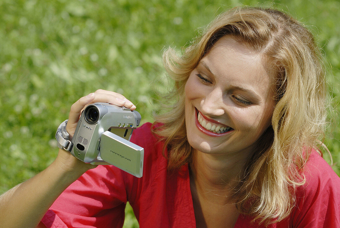 Young woman filming with a digital camcorder