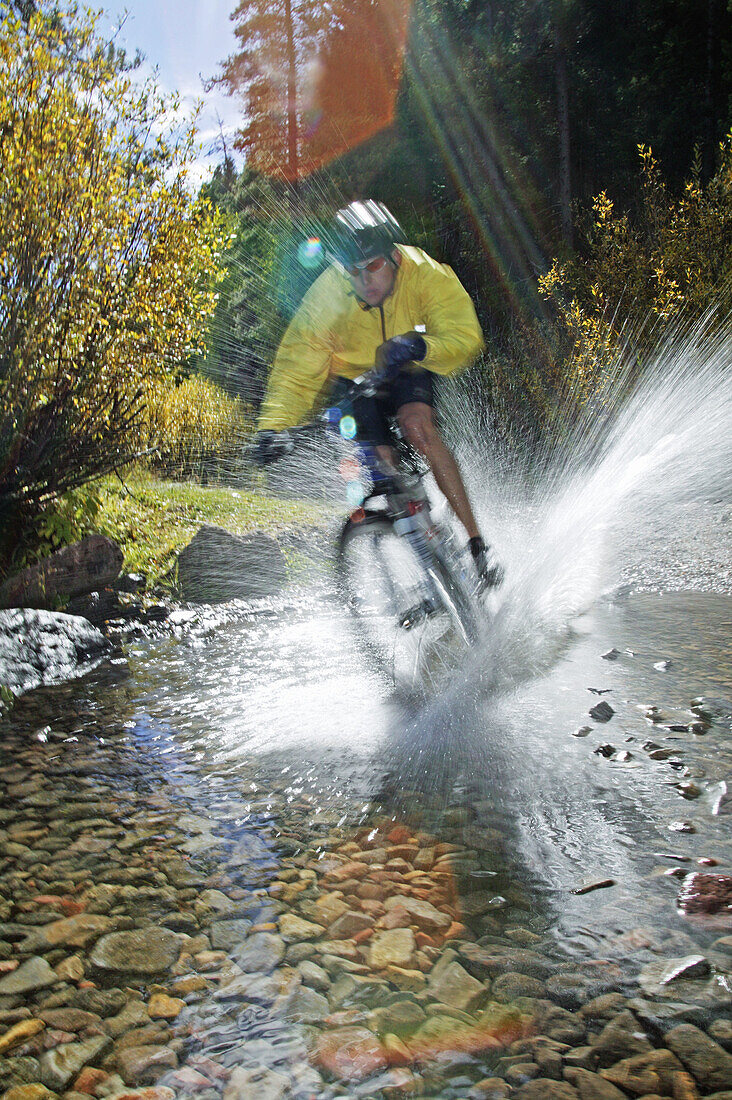 Man splashing through water on a mt. biking in Sun Valley, Idaho. USA