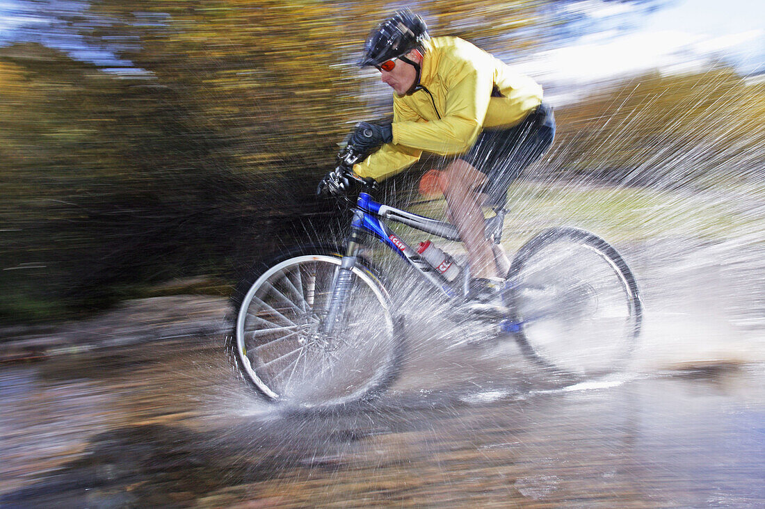 Man splashing through water on a mt. biking in Sun Valley, Idaho. USA