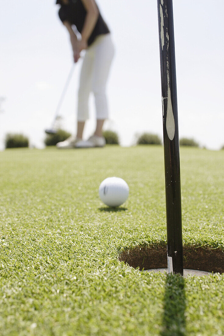 Aim, Aiming, Ball, Balls, Close up, Close-up, Closeup, Color, Colour, Concept, Concepts, Daytime, Detail, Details, Exterior, Golf, Golf course, Golf courses, Ground, Grounds, Hole, Holes, Human, Leisure, Object, Objects, One, One item, One person, Outdoor