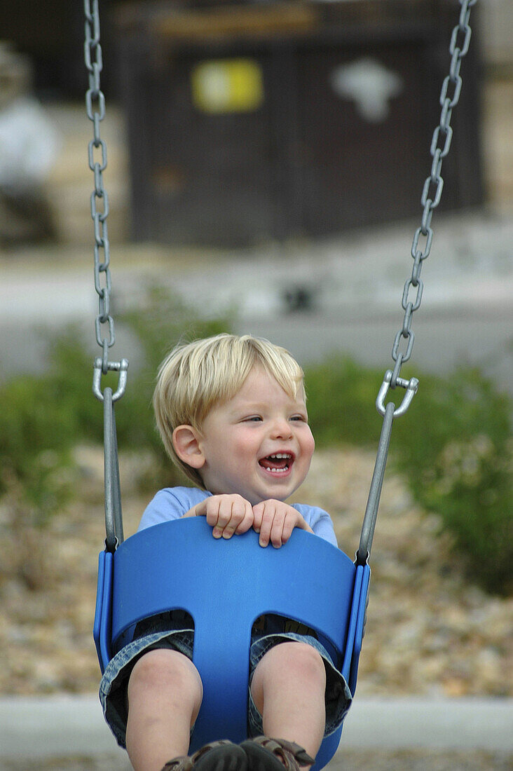 Toddler laughing on swing