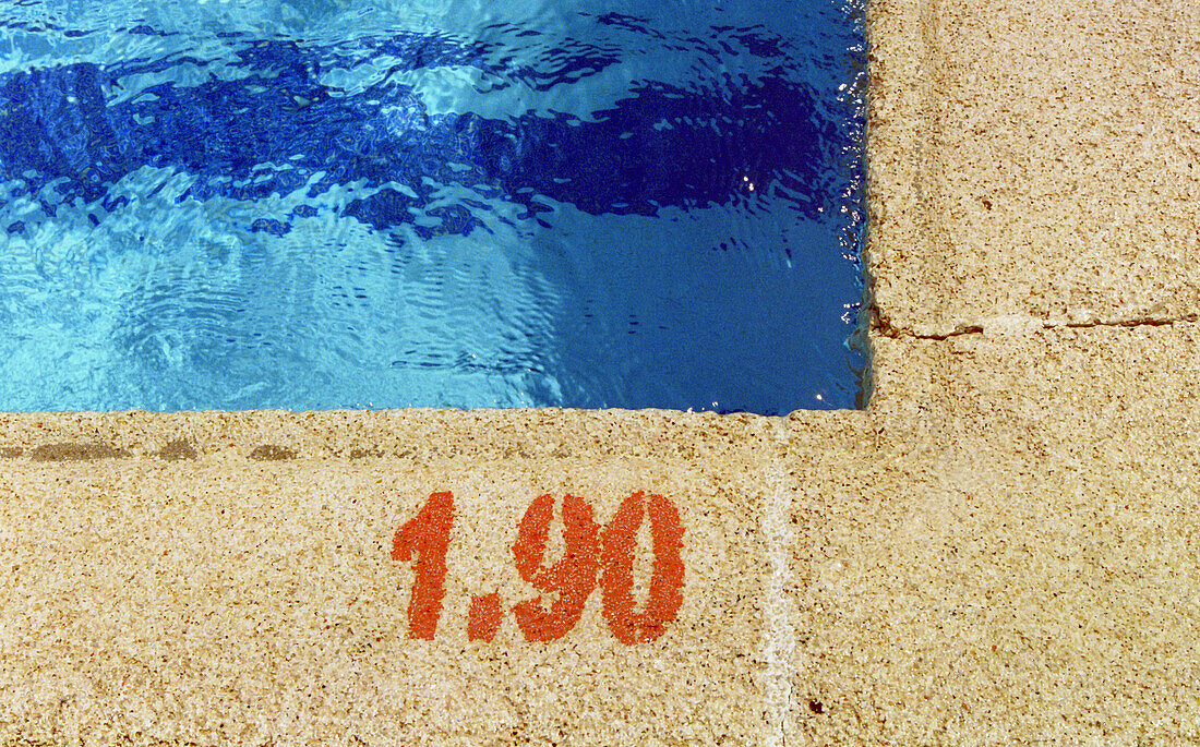 Swimming pool curb with depth sign