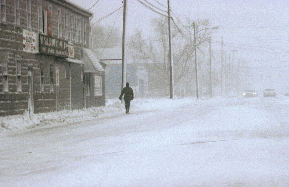 Man walking on snow covered Malory street. Phoebus, Hampton, Virginia