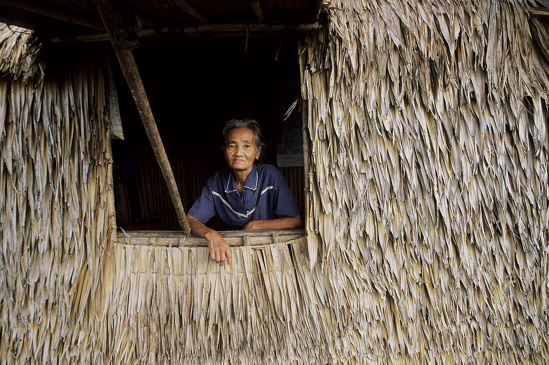 Old woman in grass hut in Cagayan Provence, Luzon, Philippines.