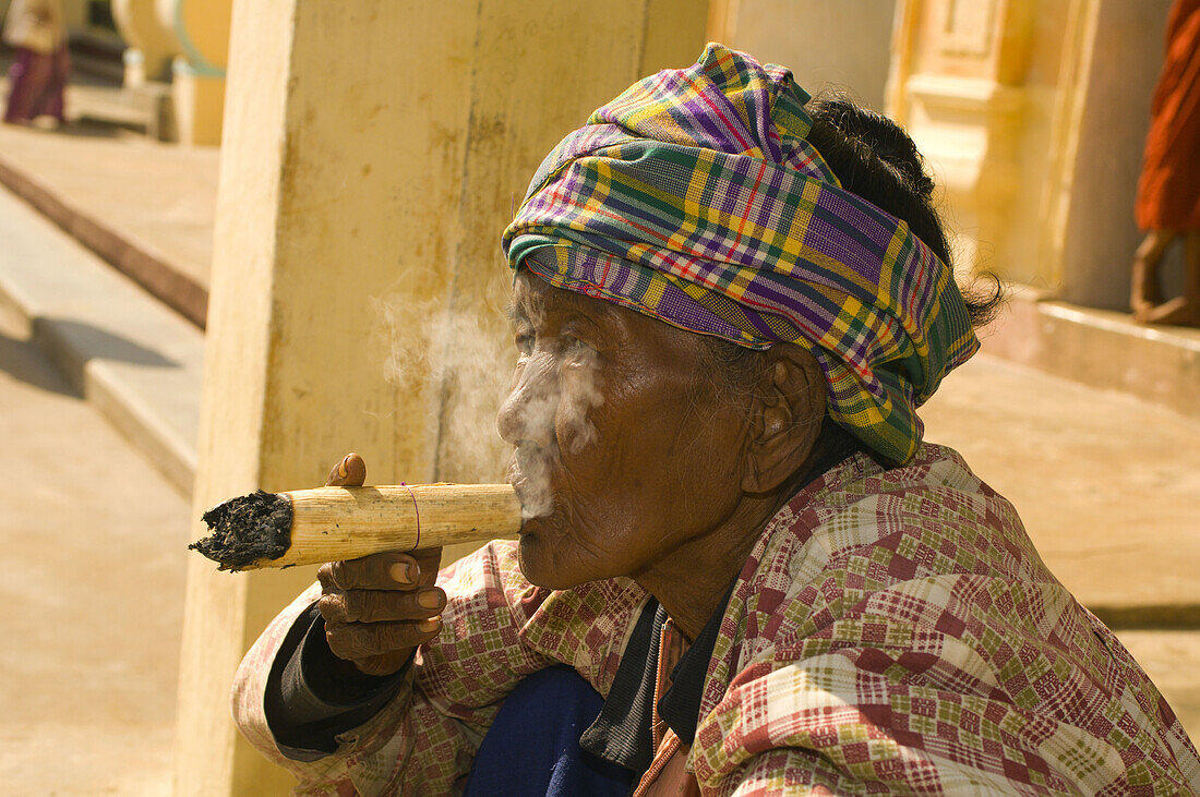 Woman smoking cheroot outside the Shwezigon Pagoda, Bagan, Myanmar (Burma)