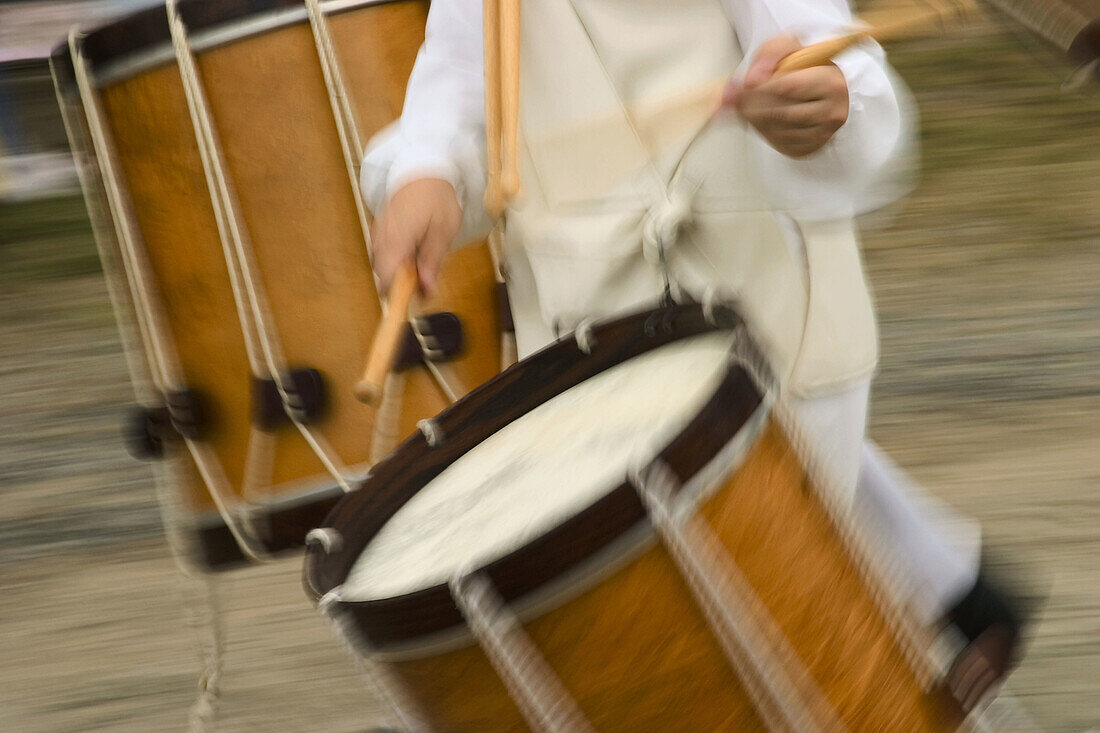 Close-up of a preteen boys hands playing a drum while marching with his fife and drum corps.