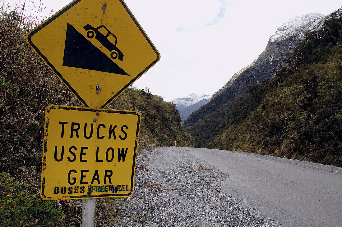 Trucks use low gear, buses freewheel. Sign at beginning of descent from Wilmot Pass, road to Doubtful Sound, Fiordland National Park, New Zealand