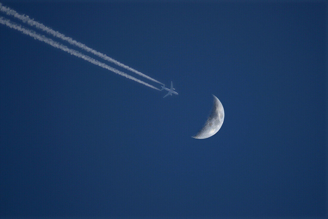 Flying plane just passing ower the moon.
