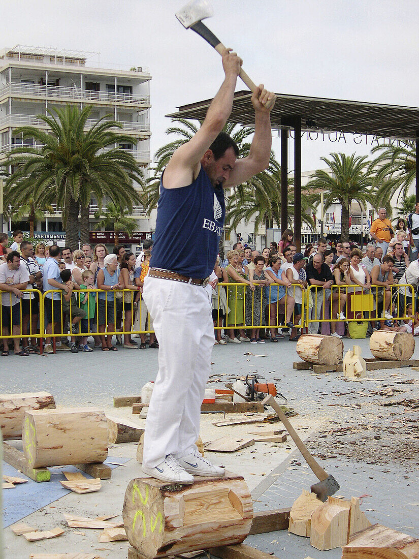 Aizkolari man cutting log with an axe, demonstration of aizkora (traditional Basque sport). Salou, Tarragona province. Catalonia, Spain
