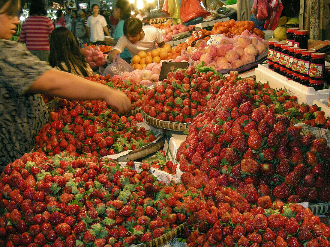 Frau kostet Erdbeeren auf dem Großmarkt, Baguio, Benguet Provinz, Luzon, Philippinen, Asien