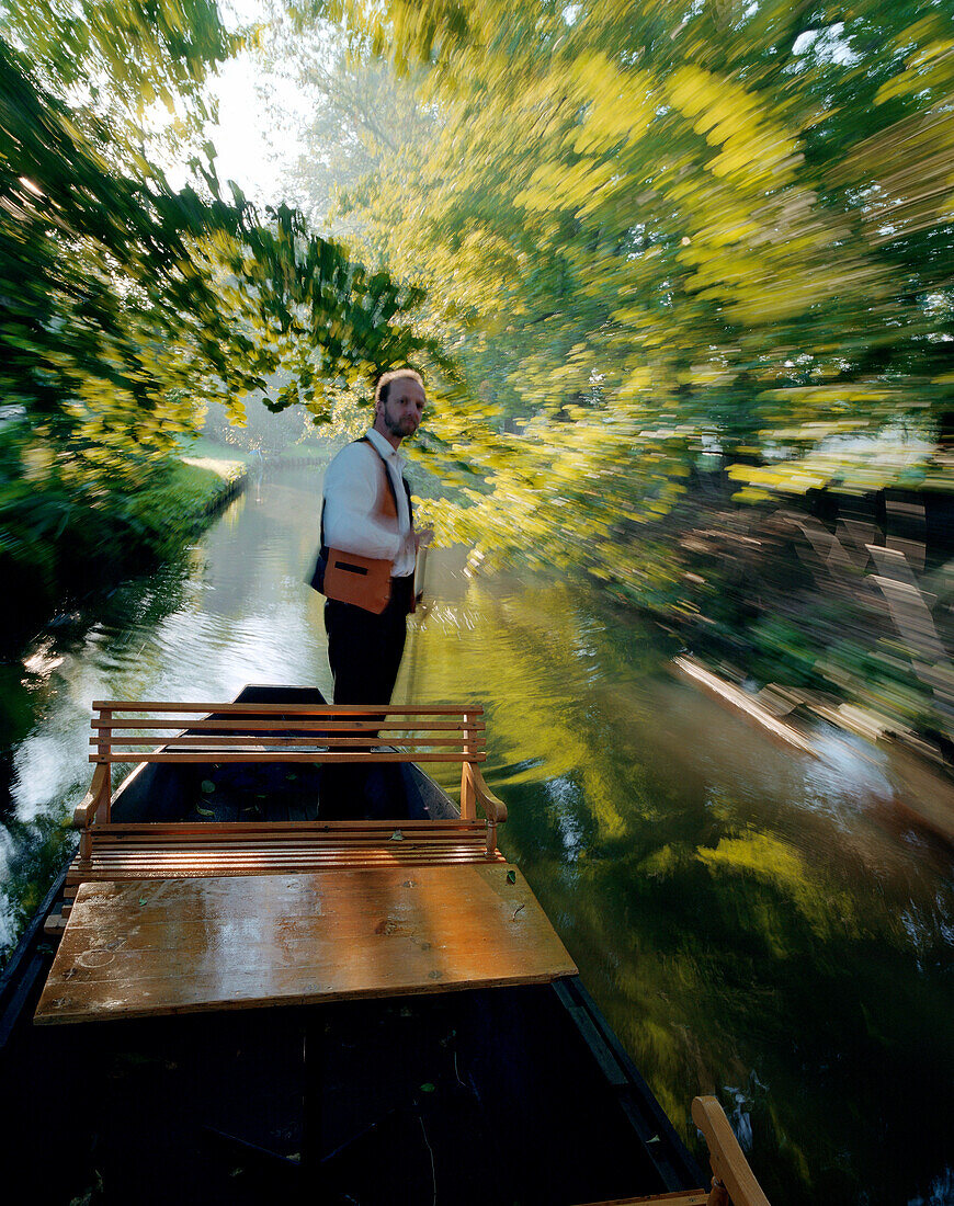 Traditional Spreewald boat in the morning, tourguide Hagen Conrad punting on a stream to pick up tourists in Burg-Kauper, Upper Spreewald, biosphere reservat, Spreewald, Brandenburg, Germany