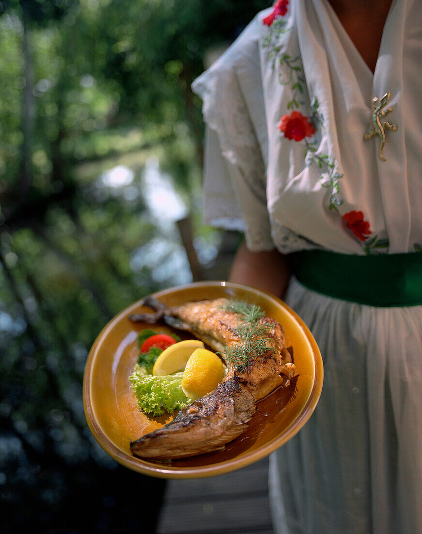 Frau serviert Hecht in Butter gebraten, Lehde, Spreewald, Brandenburg, Deutschland