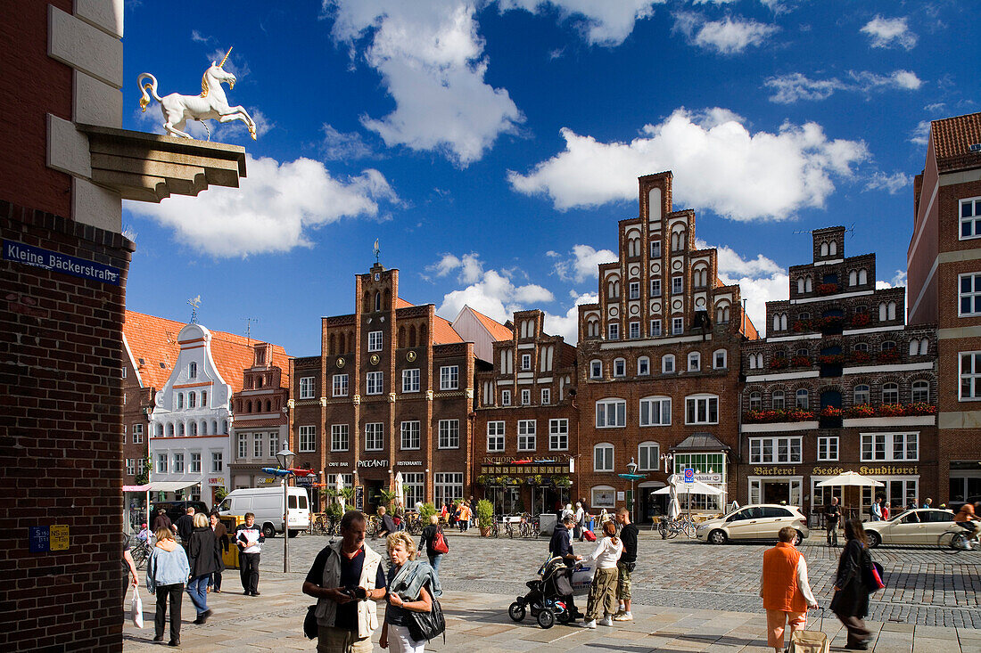 Fussgänger vor Giebelhäusern unter blauem Himmel, Lüneburg, Niedersachsen, Deutschland, Europa