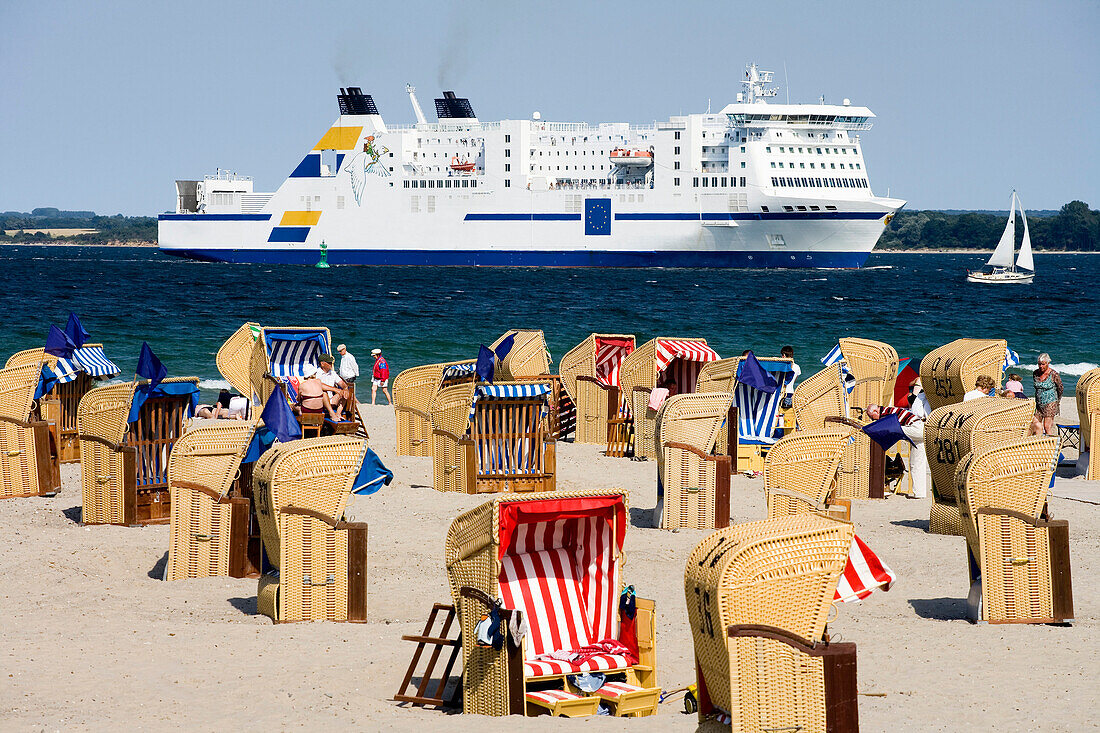 Beach chairs at beach, ferry in background, Travemunde, Lubeck, Schleswig-Holstein, Germany