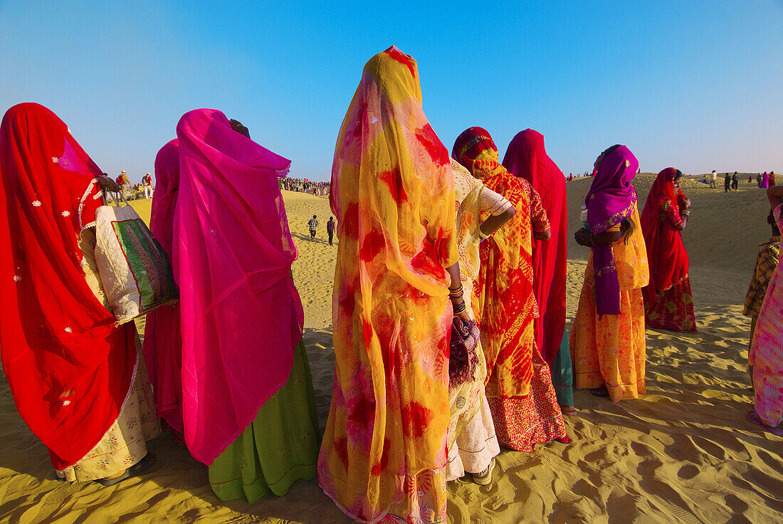 Women wearing colorful saris, Desert Festival at the Sam Sand Dunes, Thar Desert, near Jaisalmer, Rajasthan, India