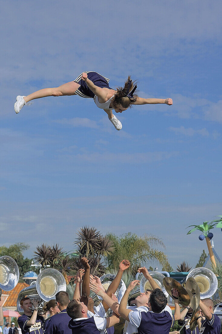 Cheerleader flying during a college parade in San Diego, California.