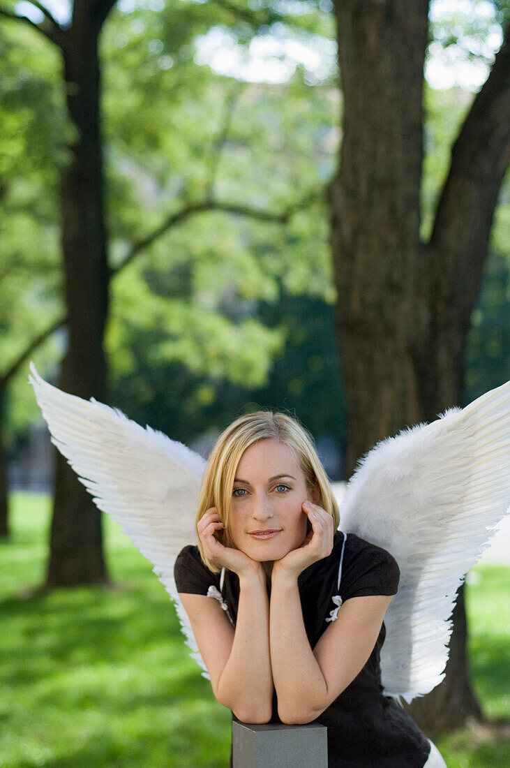 Mid adult woman wearing angel wings in a park
