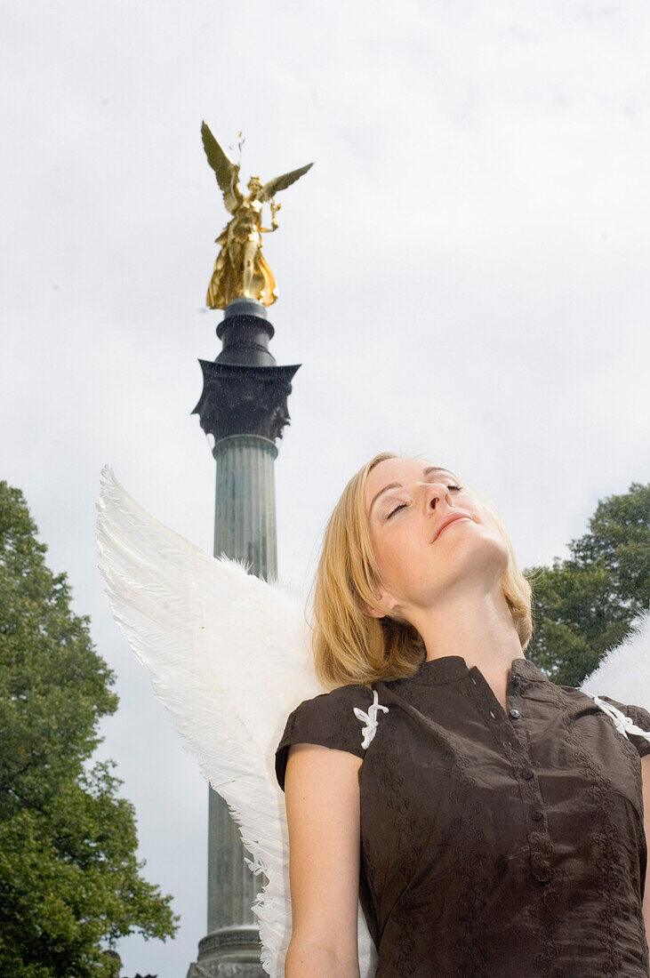 Engel, junge Frau mit Engelsflügeln beim Friedensengel, München, Bayern, Deutschland