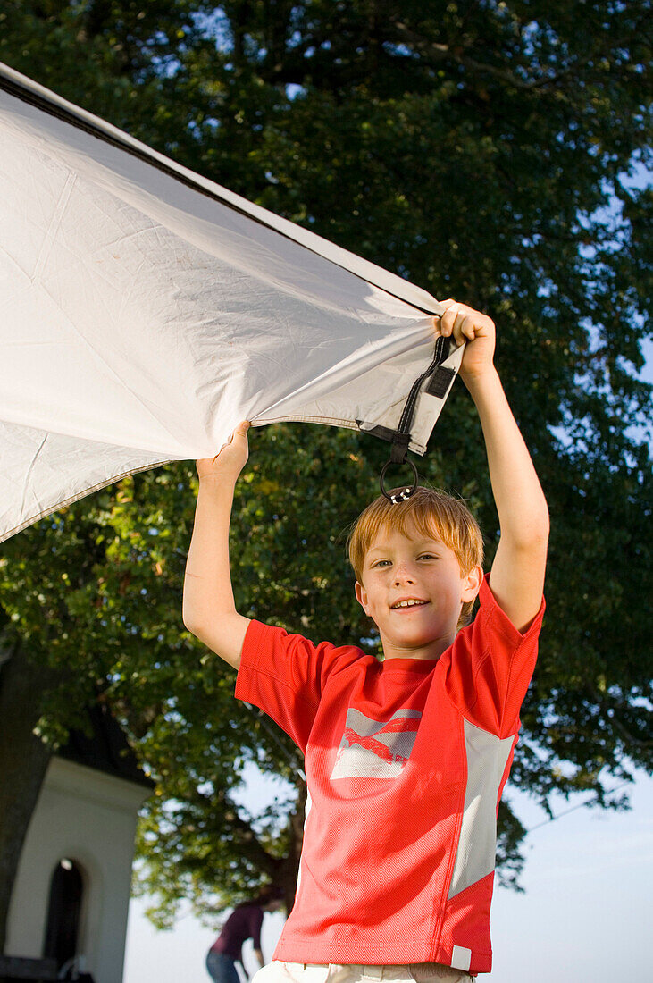 Boy (10-11 years) putting up a tent