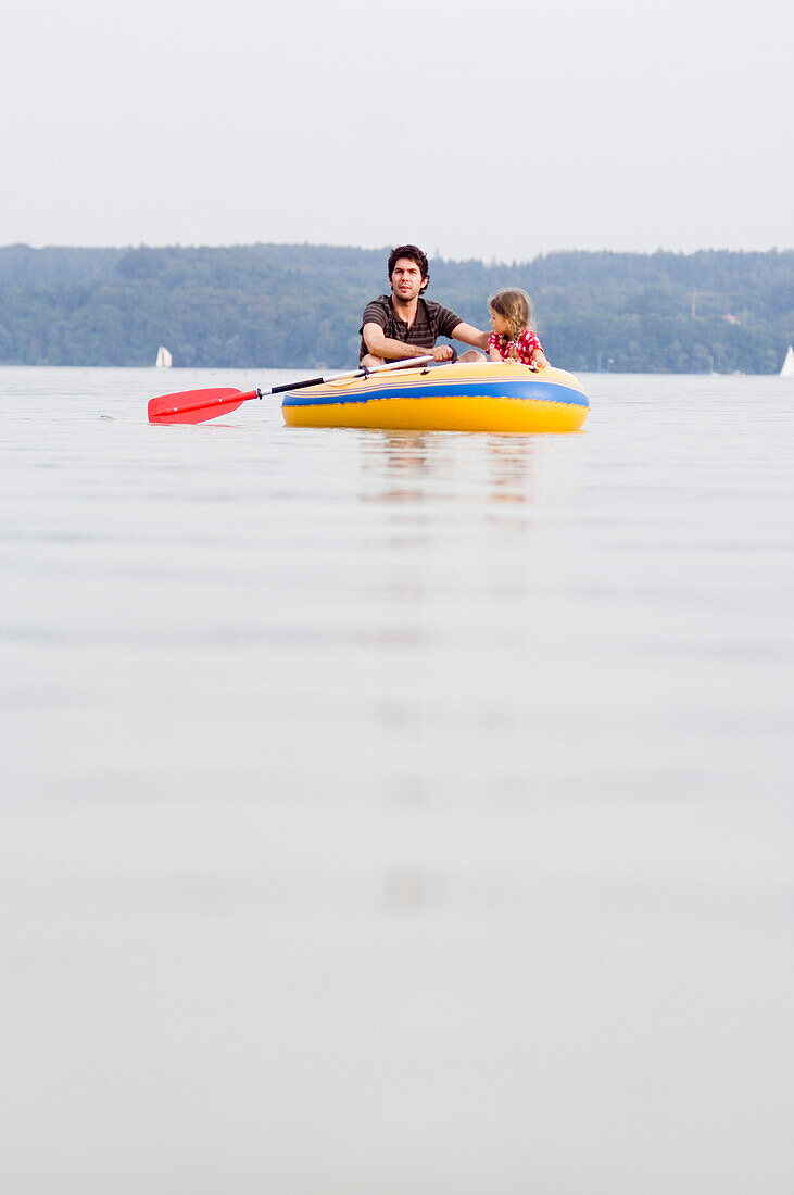 Vater und Tochter (3-4 Jahre) in einem Gummiboot auf dem Ammersee, Bayern, Deutschland