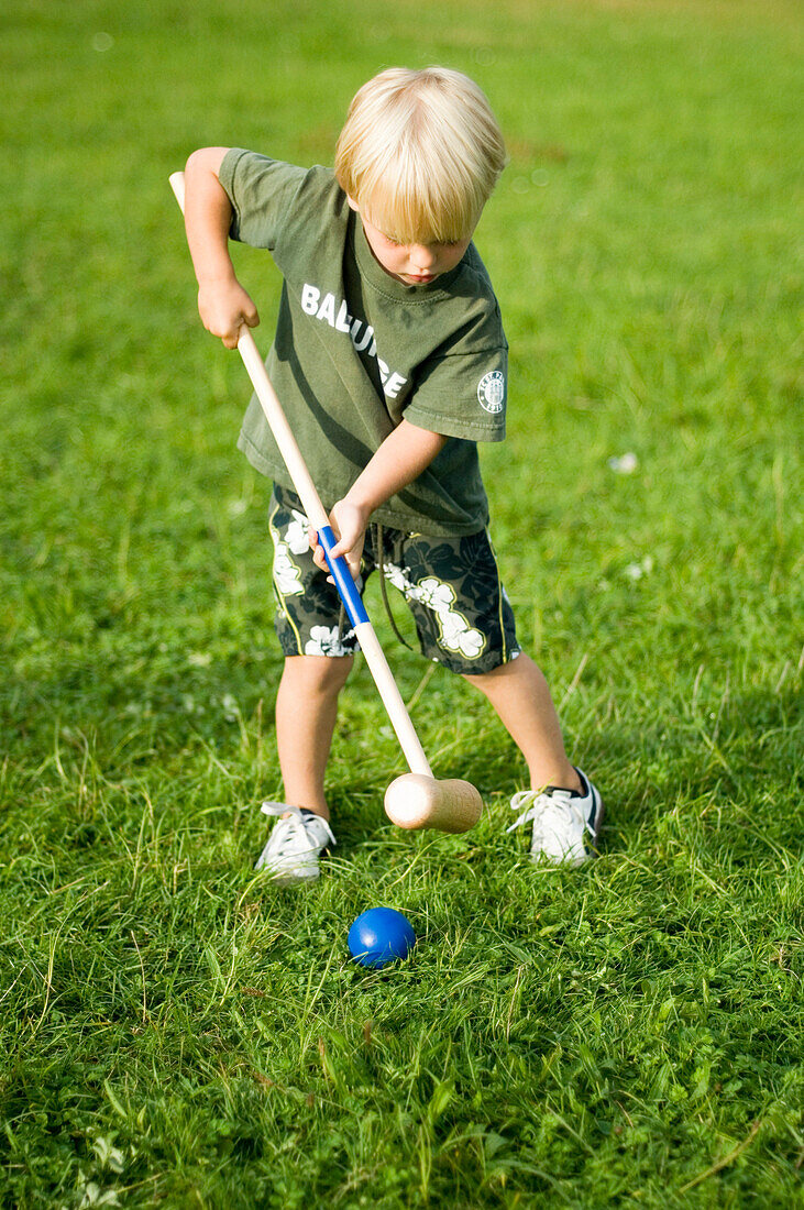 Junge (3-4 Jahre) spielt Krocket, Bayern, Deutschland