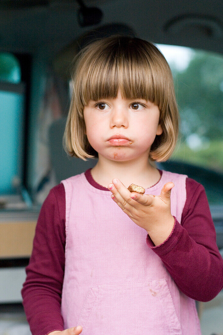 Girl (4-5) eating a biscuit, Bavaria, Germany