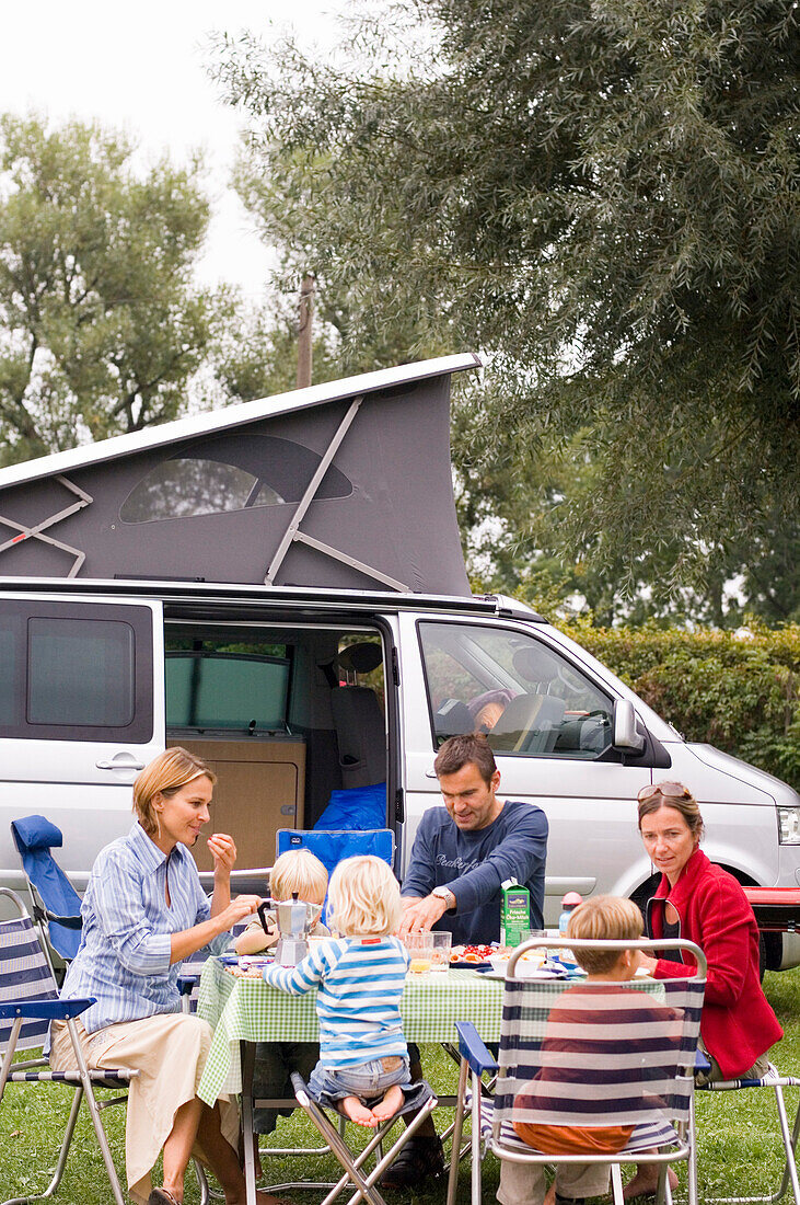 Familie beim Frühstück vor Wohnmobil