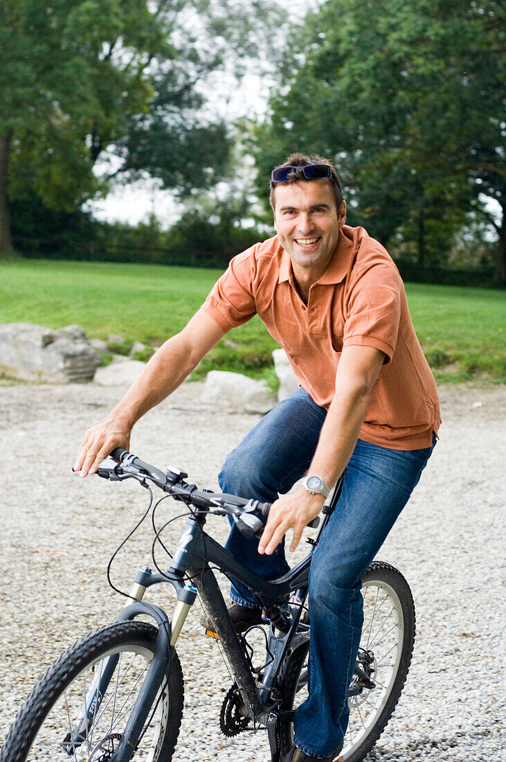 Mann mittleren Alters fährt Fahrrad, Bayern, Deutschland