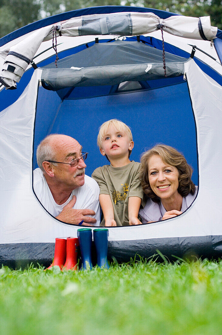 Großeltern und Enkelsohn in einem Zelt