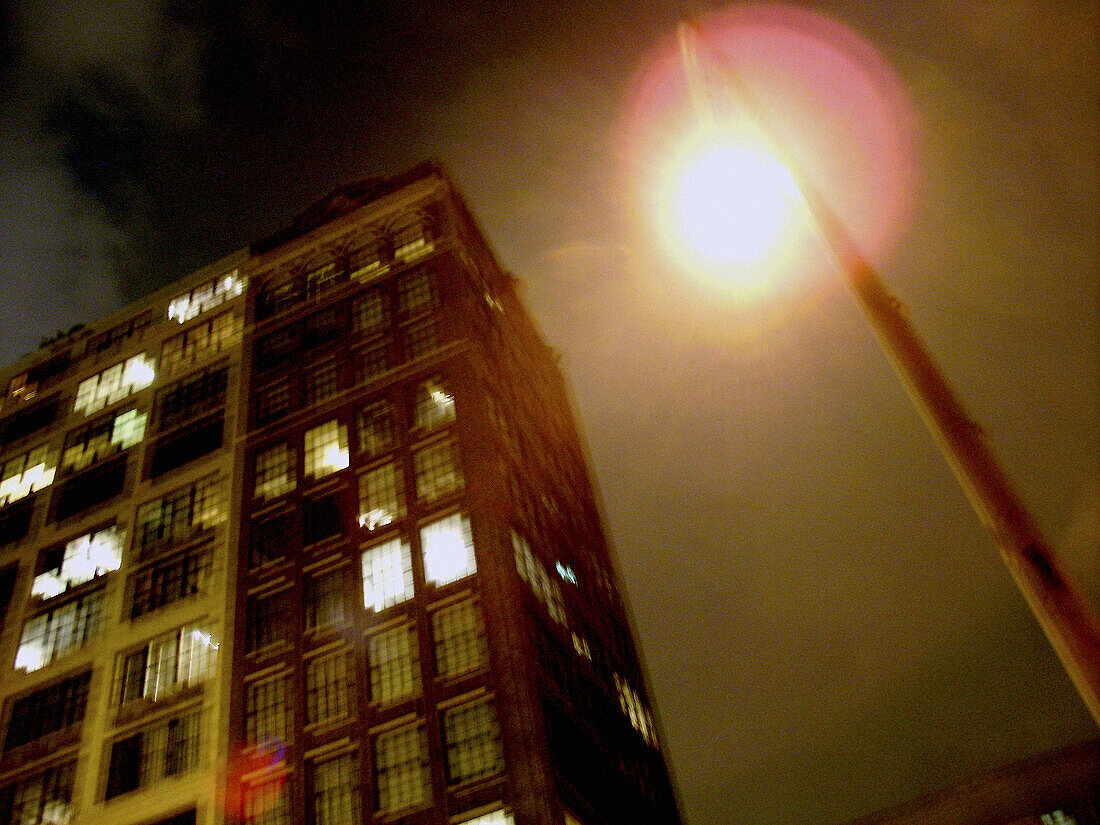 Slightly blurred loft buildings in New York City captured at night, helped by the light from a streetlight. USA