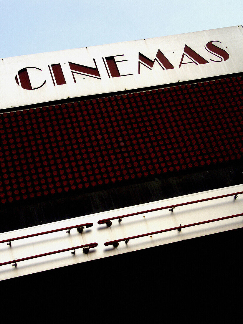 Cinema marquee shot against bright blue sky.
