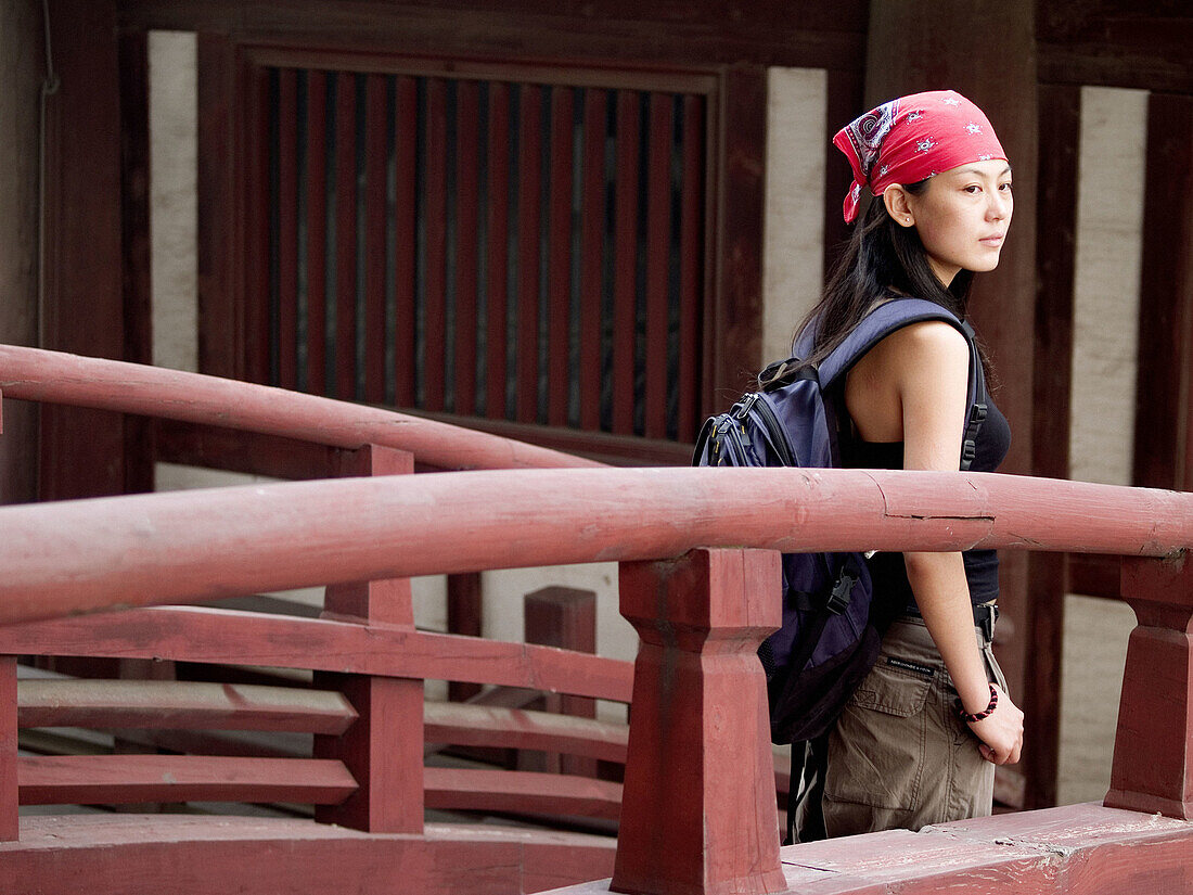Young asian (Chinese) female walking on a bridge of an ancient temple in Zhengding. Hebei, China