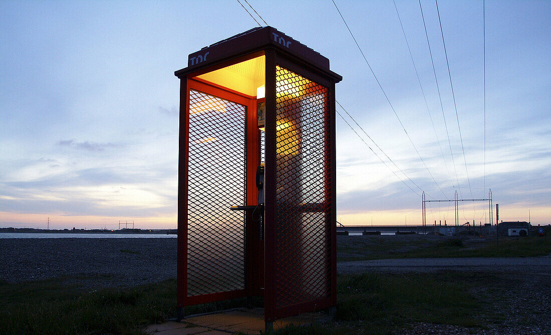 Phone booth at night with powelines in the background symbolising communication and connections