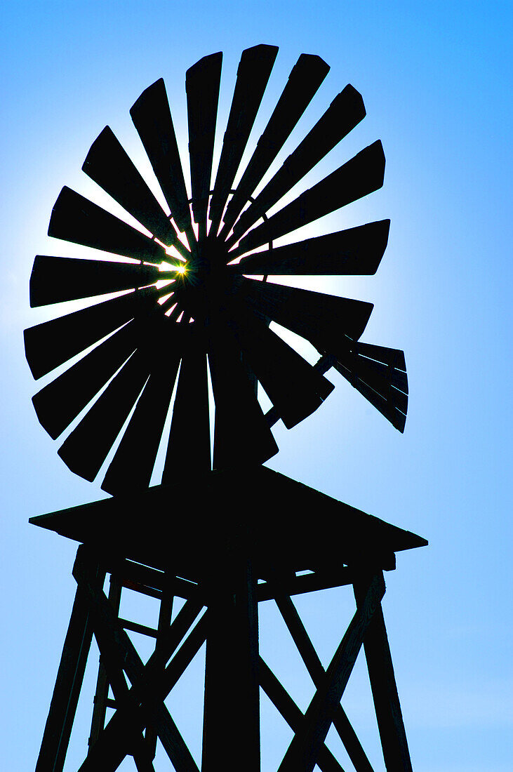 Outline of rural windmill against blue sunny sky