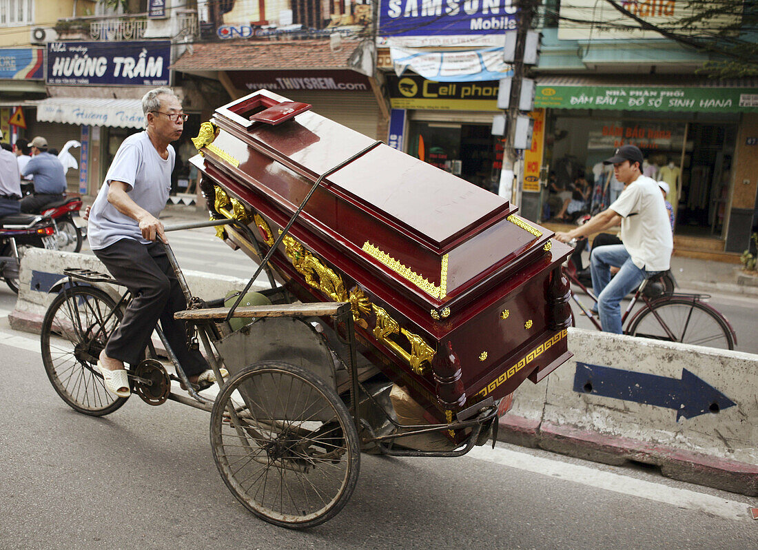 Man transporting a coffin on rickshaw. Hanoi. Vietnam.