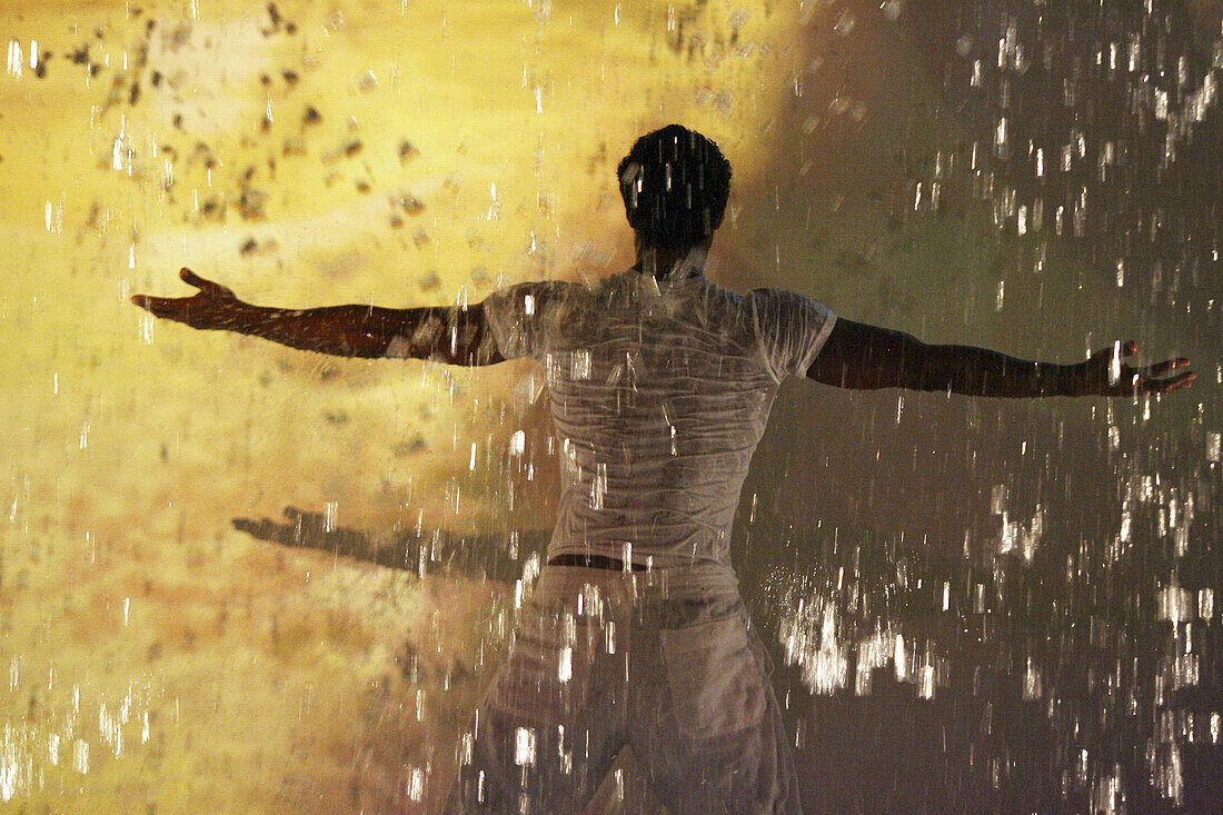 Man playing with fountain water.