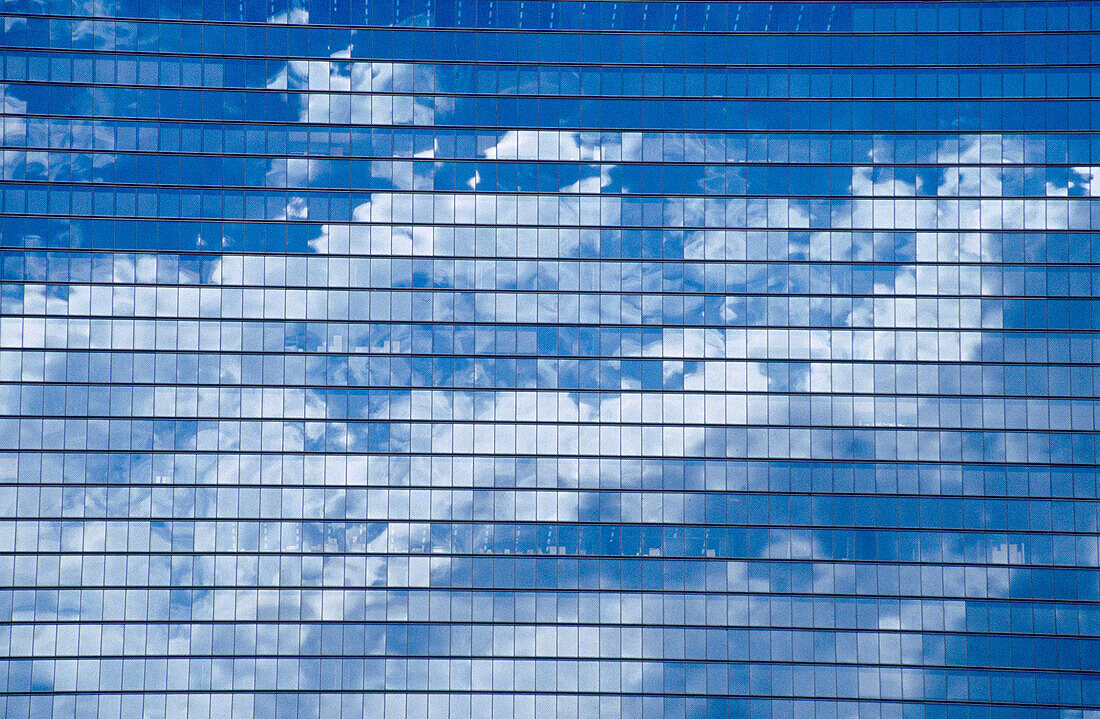 Clouds and blue sky caught in the reflection of office tower windows in Osaka-Jo Park. Kyobashi. Osaka. Japan.