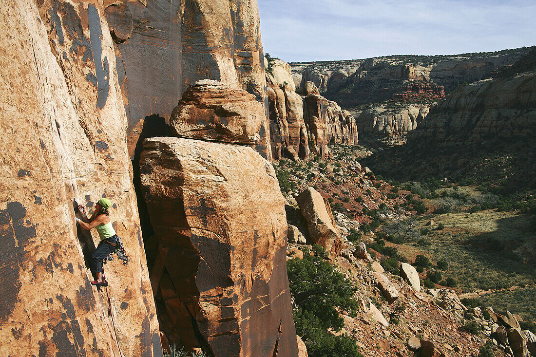 Female climber leading a crack climb in Indian Creek, Utah near Canyonlands National Park. USA