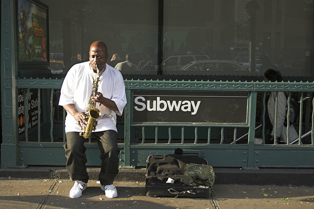 Man playing saxophone on street at Subway entrance. NYC. USA.