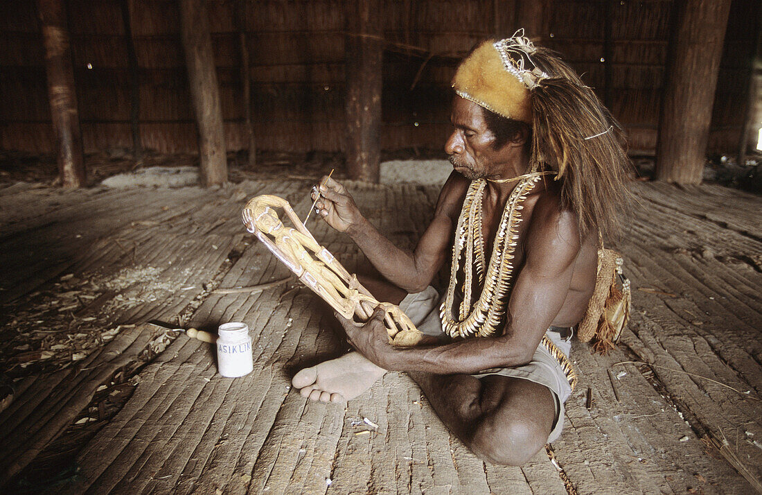 Asmat man carving a statue, Western Papuasia, Former Irian-Jaya, Indonesia