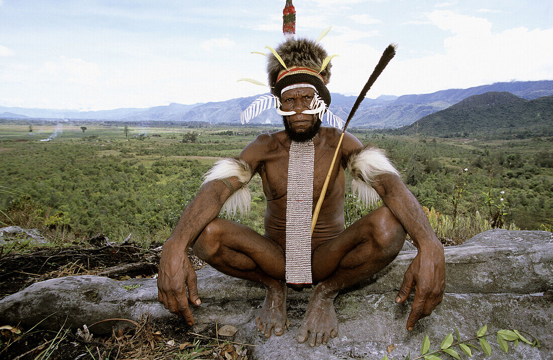 Dani man with painted face, head-dress, nose adornment made of bones and penis case, Western Papuasia, Baliem valley, Former Irian-Jaya, Indonesia