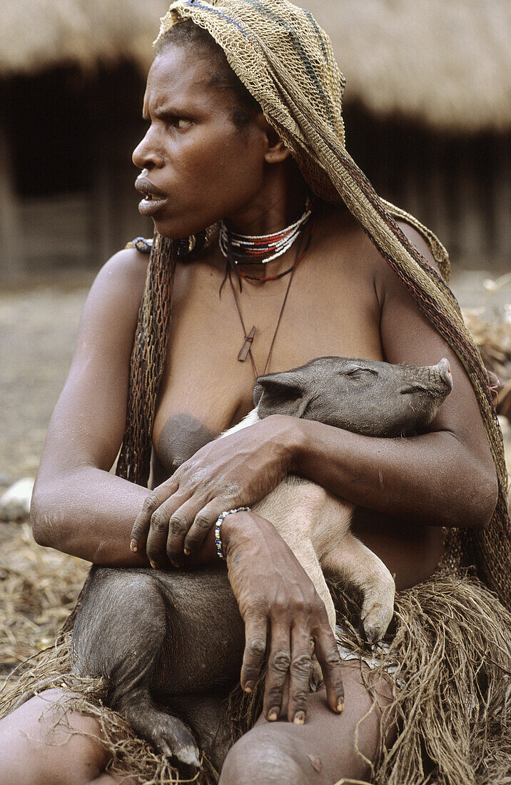 Dani woman holding a piglet in her arms, Baliem valley, Western Papuasia, Former Irian-Jaya, Indonesia