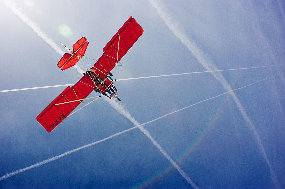 Aircrafts, Blue, Blue sky, Color, Colour, Daytime, Exterior, Flight, Flights, Fly, Flying, Low angle view, Microlight aircraft, Microlights, Outdoor, Outdoors, Outside, Red, Skies, Sky, Transport, Transportation, Transports, Travel, Traveling, Travelling,