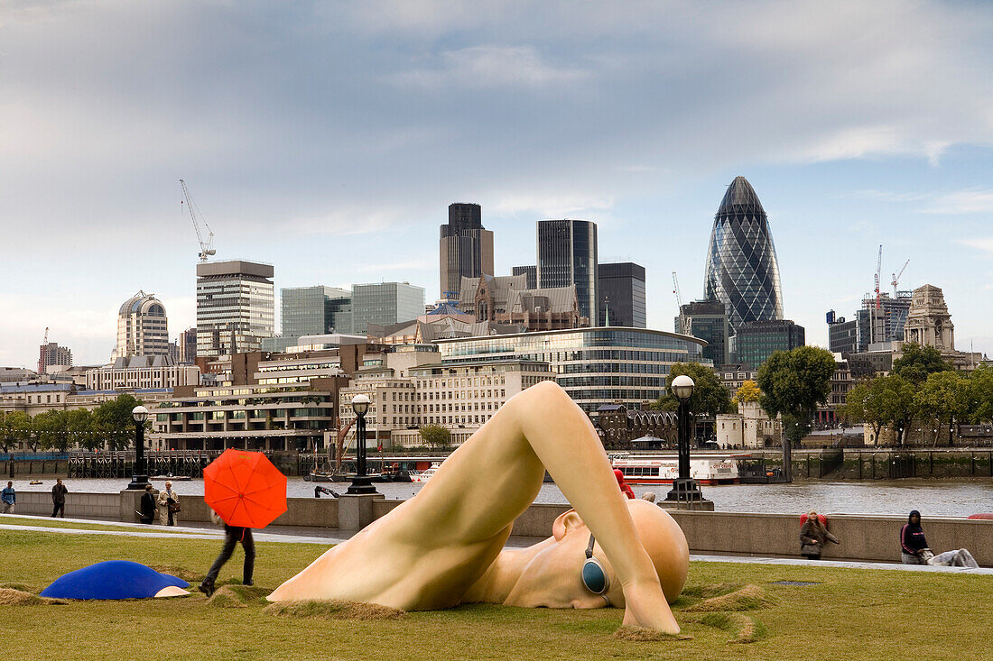 Modern swimming sculpture along the banks of the Themse, Swimmer, with Swiss Re Headquarters in the background, City of London, London, England, Europe